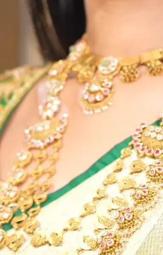 A bride wearing layered gold and kundan from the shop