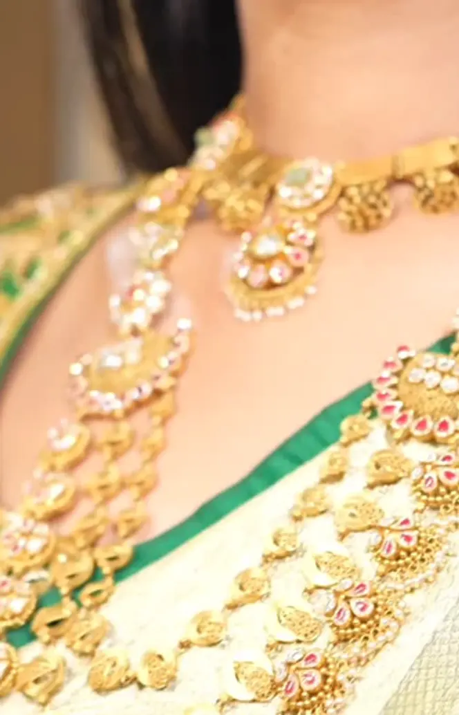 A bride wearing layered gold and kundan from the shop