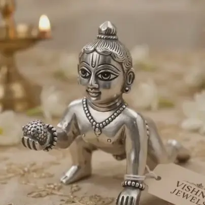 Silver crawling baby Krishna idol with a Vishnu Jewels tag